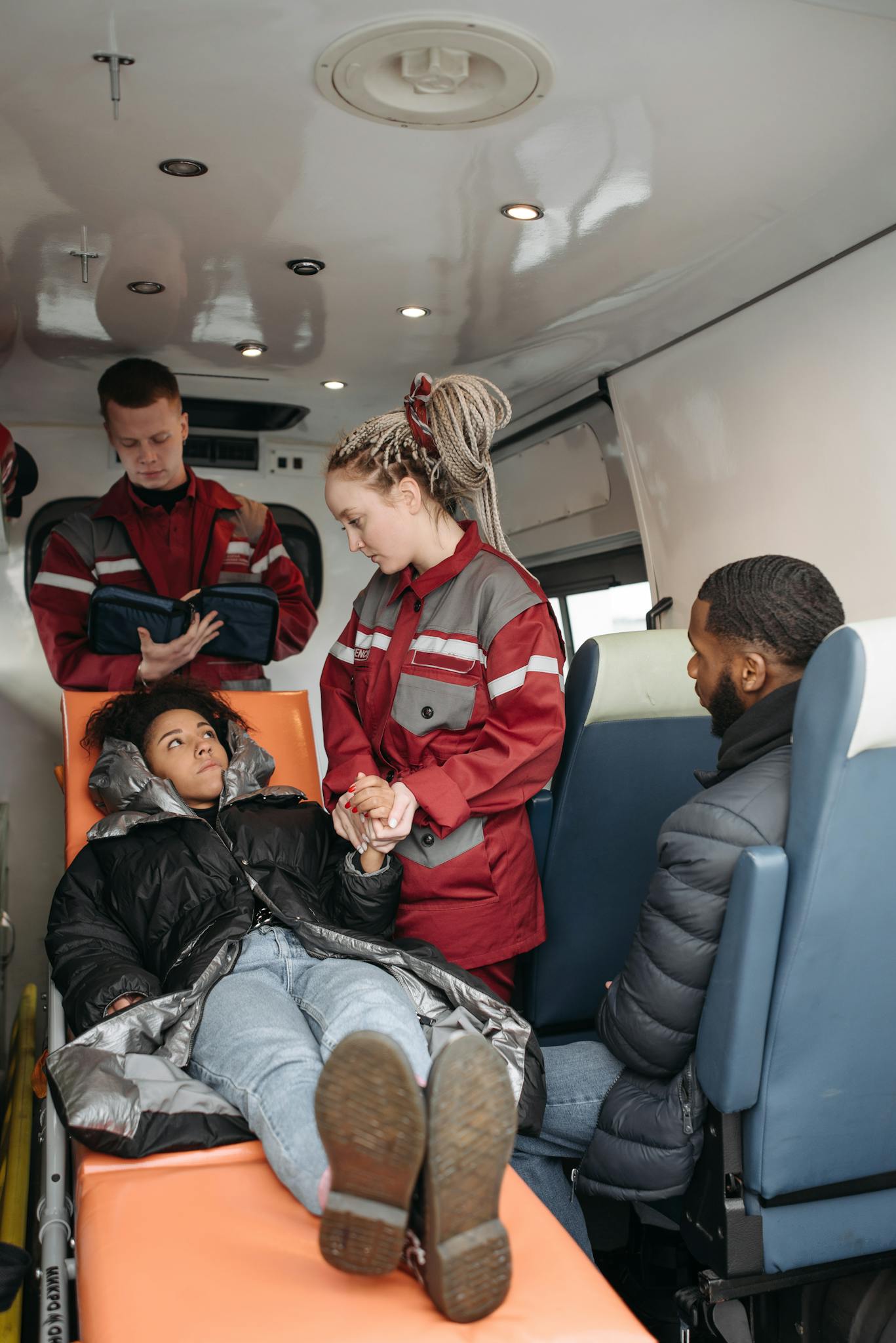 Emergency medical team aids patient on stretcher inside ambulance, fostering care.